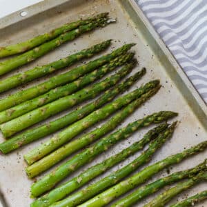 The roasted asparagus on a sheet pan after it came out of a 350° oven.
